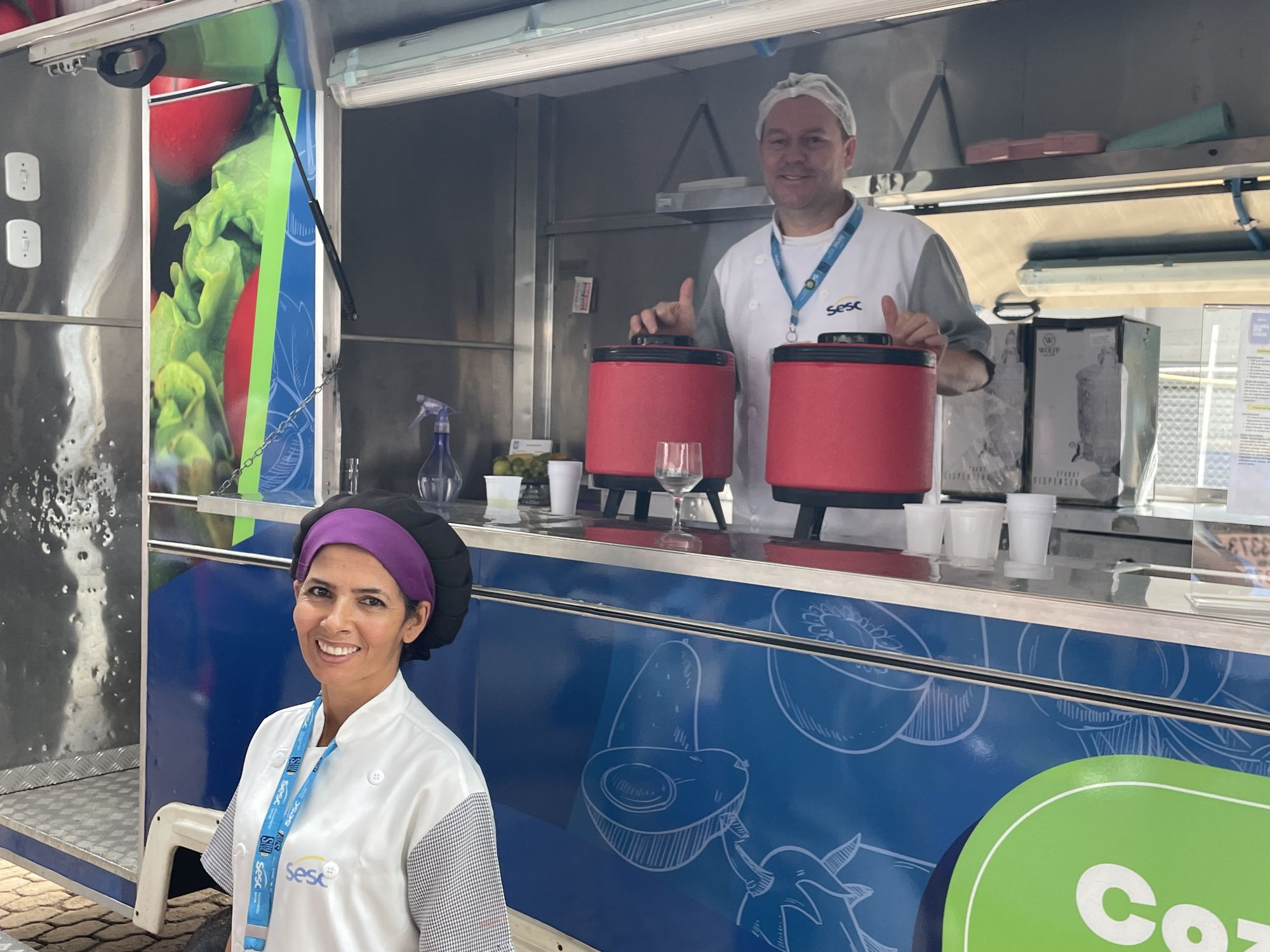 Two SESC Mesa Brasil staff members waiting to serve zero waste snacks and healthy drinks during the excursion.
