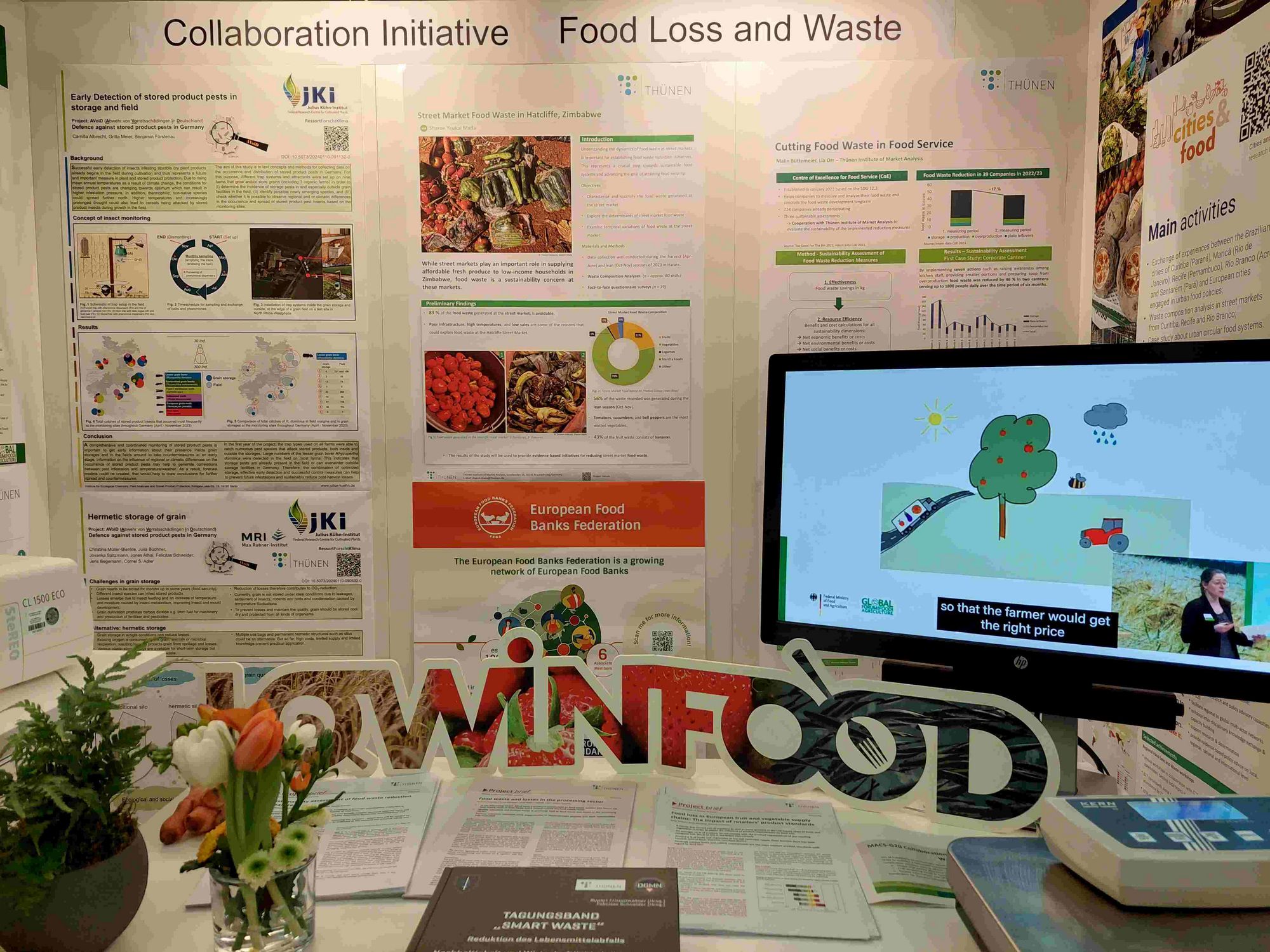 The photo shows part of our GFFA 2024 exhibition booth with posters, banner, video, plate waste scale and information material.